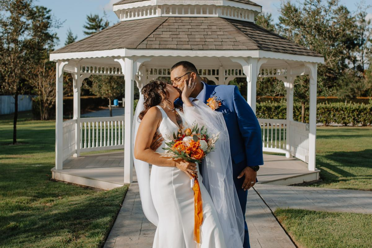 Bride and Groom Kissing in Front of Gazebo